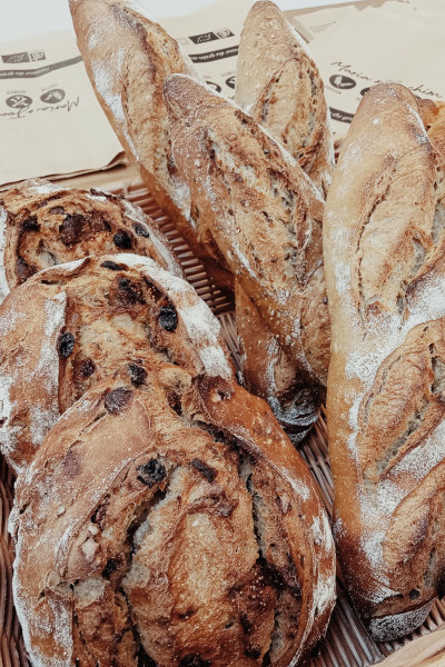 Corbeille de pains artisanaux bio — baguettes aux graines et pains aux fruits secs au levain naturel, Ferme de Logonet, Sauzon, Belle-Île-en-Mer