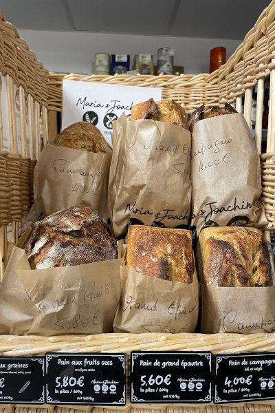 Pains artisanaux bio de la Ferme de Logonet en sachets kraft à la Supérette Vival de Sauzon, Belle-Île-en-Mer — pain aux fruits secs, grand épeautre, pain de campagne
